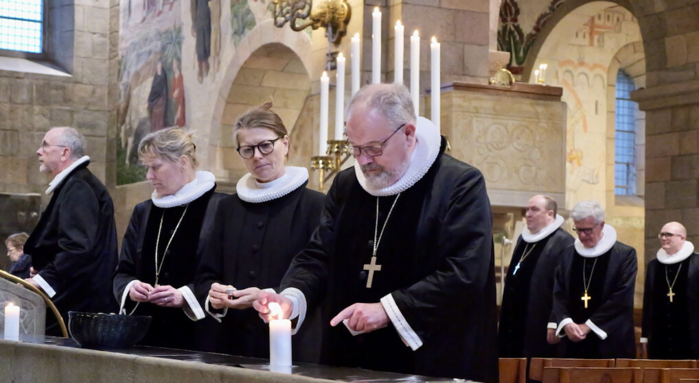 Billede af biskop Elof Westergaard, der tænder et lys til freds- og forsoningsgudstjeneste i Viborg domkirke. Rundt om ham står andre præster og biskopper