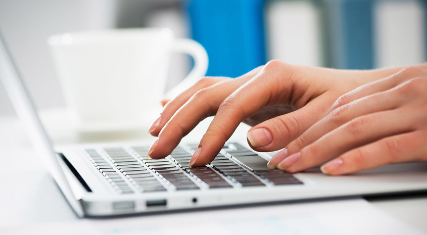 Nærbillede af hænder, der skriver på en bærbar computer