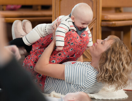 En ung kvinde ligger på gulvet i en kirke med sin lille søn hvilende på hendes bøjede knæ